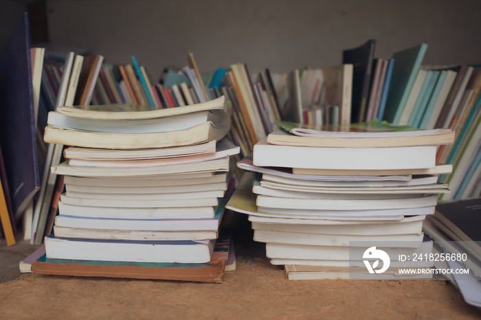 Untidy bookshelf with a pile of books