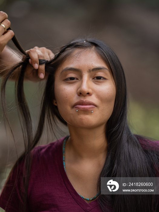 一位年轻的土著妇女在编辫子时微笑的肖像