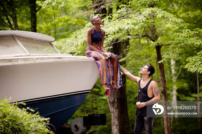 Man looking at woman sitting on boat in forest