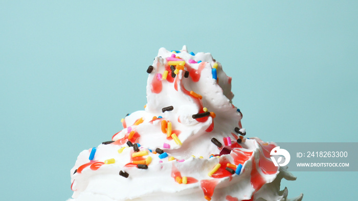 Close up Sweet candy full many colors on Whip cream on blue background, Food concept Front view..