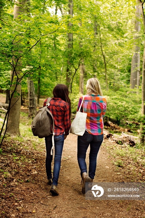 Two young walking on path in forest