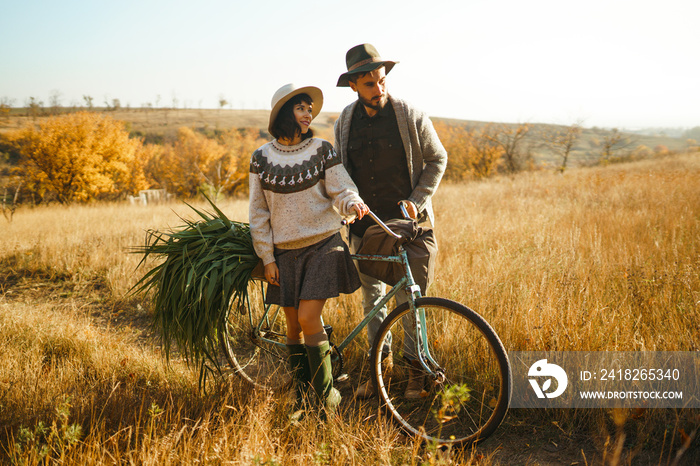 Lovely hipster couple with bike . Couple wearing beautiful hats and sweaters. Lifestyle, happy coupl