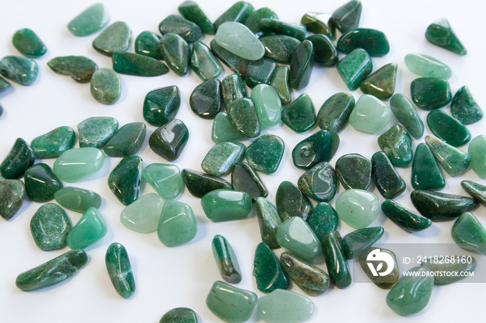 Macrophoto of mineral rock specimen - tumbled green aventurine gemstone on white background partial 