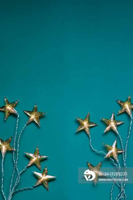 Top view of star shaped Christmas lights against green background with copy space