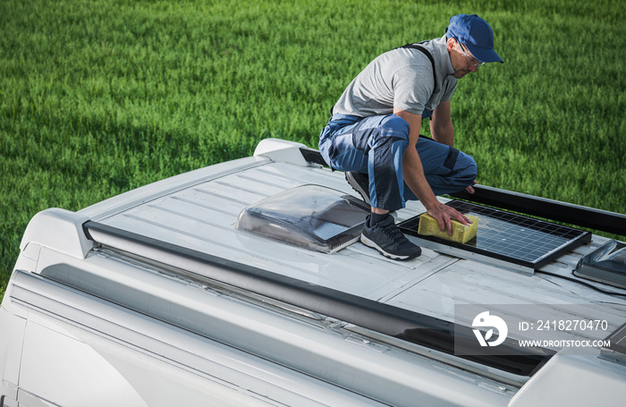 男子清洁露营车RV车顶安装的太阳能电池板