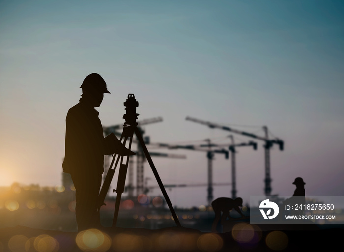 silhouette engineer looking Loaders and trucks in a building site over Blurred construction worker o