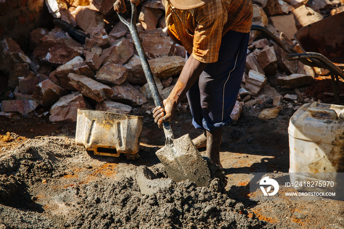 Man making cement with a shovel in Uganda, Africa