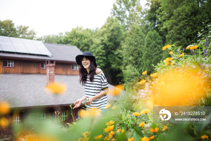 Woman in hat walking through flowers