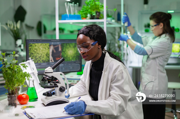 非洲生物化学医生为基因研究人员使用显微镜检查化学测试。Biological