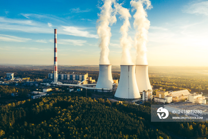 A Power plant with white smoke over its chimneys