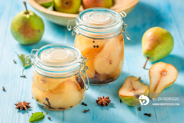 Sweet and tasty pickled pears on blue table