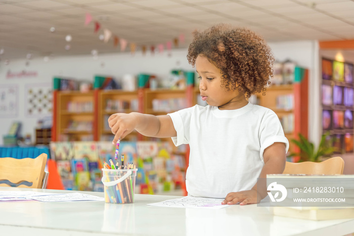 Little toddler girl concentrate on drawing.  Mix African girl learn and play in the pre-school class