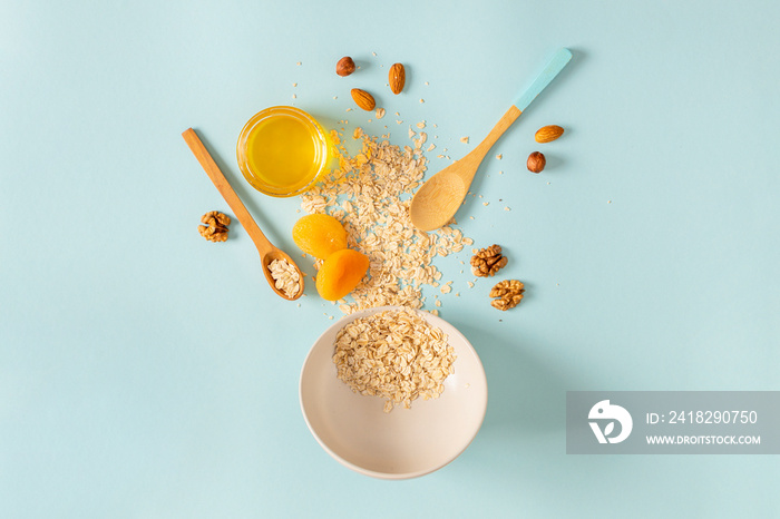 Ingredients for making breakfast with granola and fruits on blue background top view, flat lay. Cook