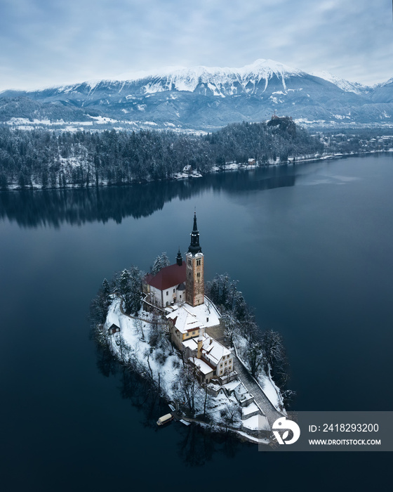 Aerial shot of lake Bled on a calm winter morning with snow