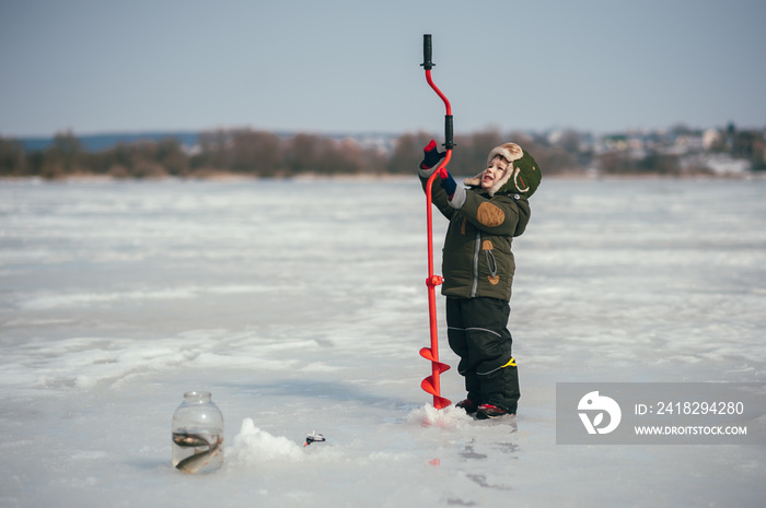 boy fishing on winter. Cute boy catches fish in the winter lake. Winter. Outdoor