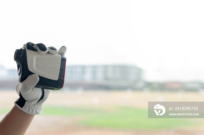 Female hands wearing professional glove with white and black modern optical range finder used for go