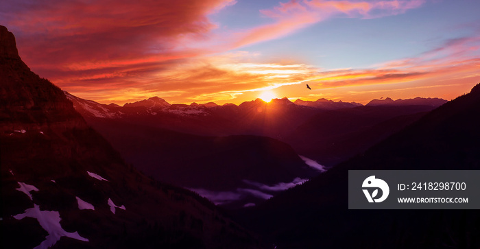 Epic Mountain Sunset Over Glacier National Park High Altitude Range of Peaks With Eagle Flying In Di