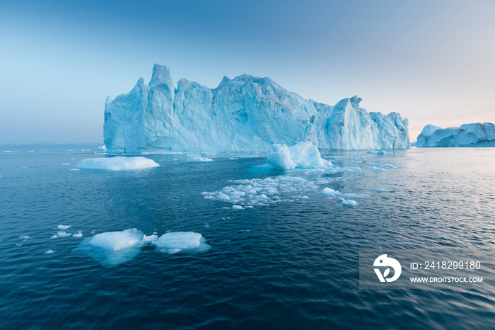 Photogenic and intricate iceberg under an interesting and blue sky during sunset. Effect of global w