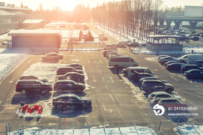 View from above on car parking with many vehicles and free lots at bright early frosty cold winter m