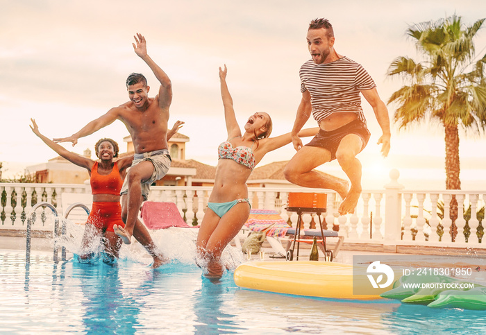 Group of happy friends drinking jumping in pool sunset party