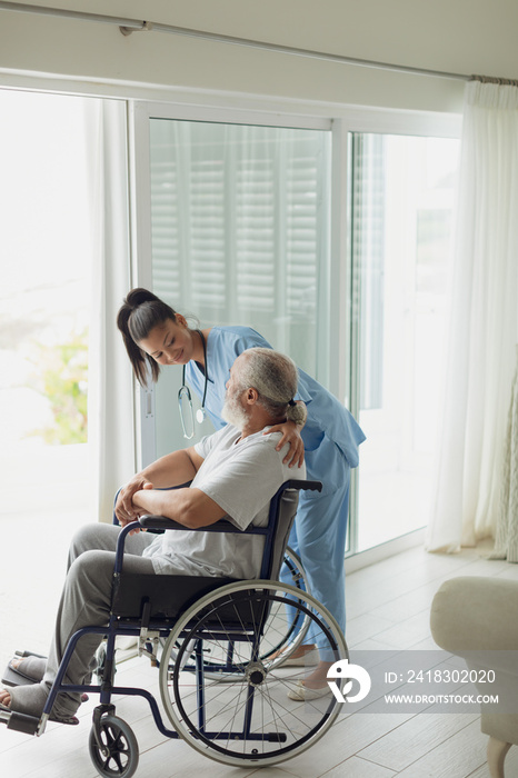 Healthcare worker talking with man on wheelchair