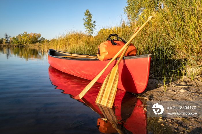 red canoe on a lake shore