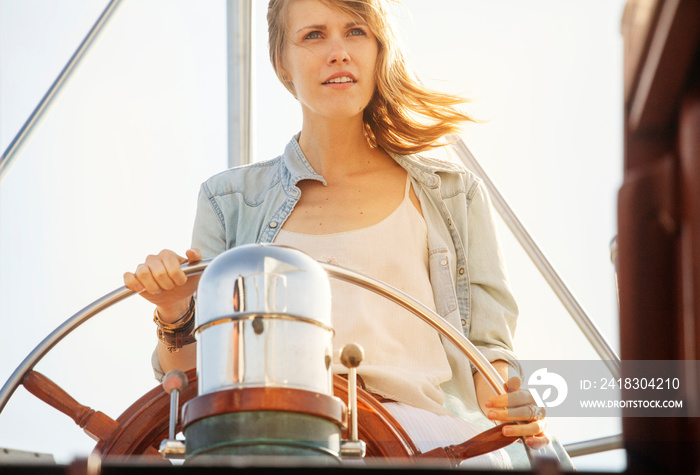 Young woman steering yacht