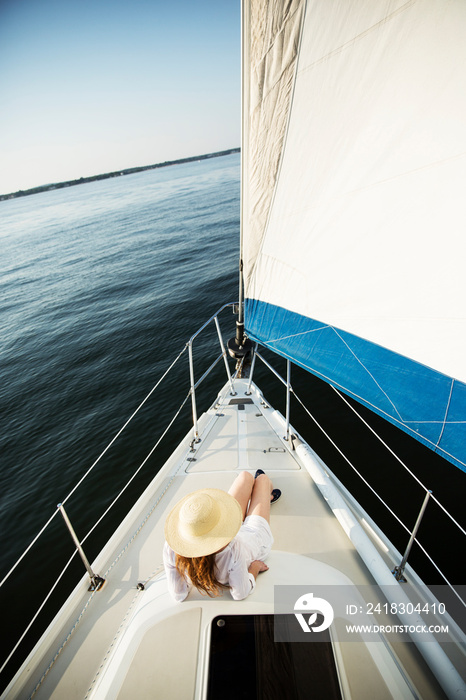 Rear view of woman sitting on deck of sail boat