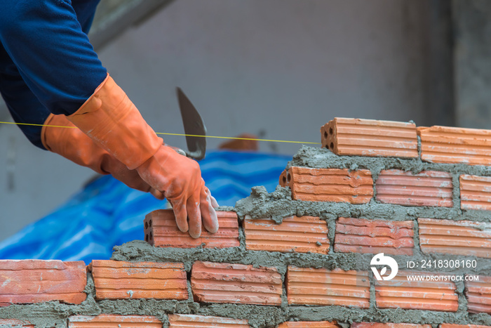 Worker installing red brick for construction site