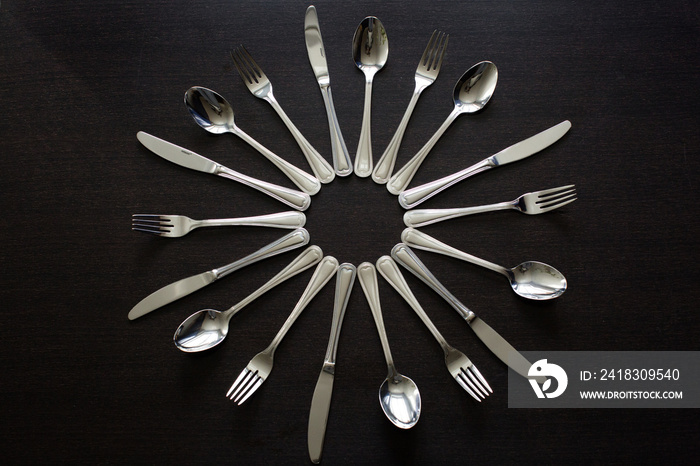 黑色背景的餐具。叉子、勺子、刀。