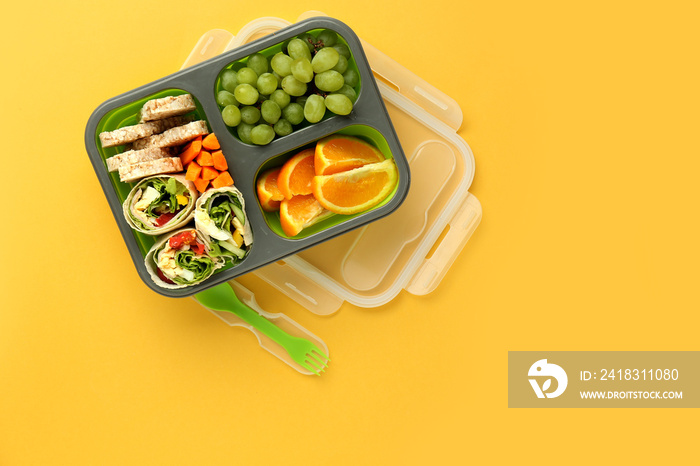 School lunch box with tasty food on color background