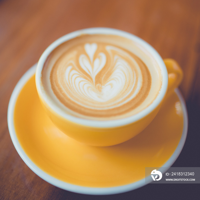 Coffee latte art in coffee shop on wooden table in the morning.