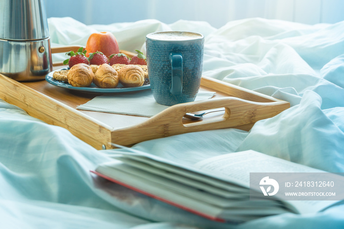 Bed and breakfast with fruits and pastries on a tray