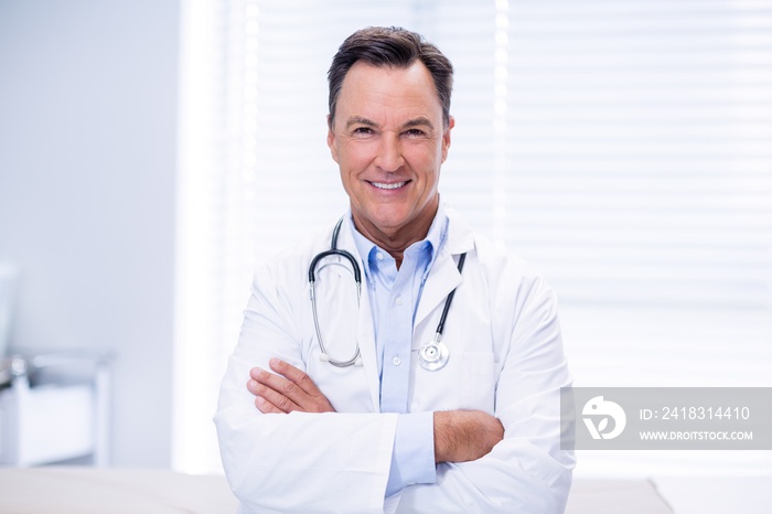 Portrait of male doctor standing with arms crossed