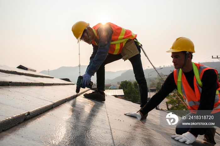 The roof work team in work clothes and special protective gloves using air guns or air nails and ins