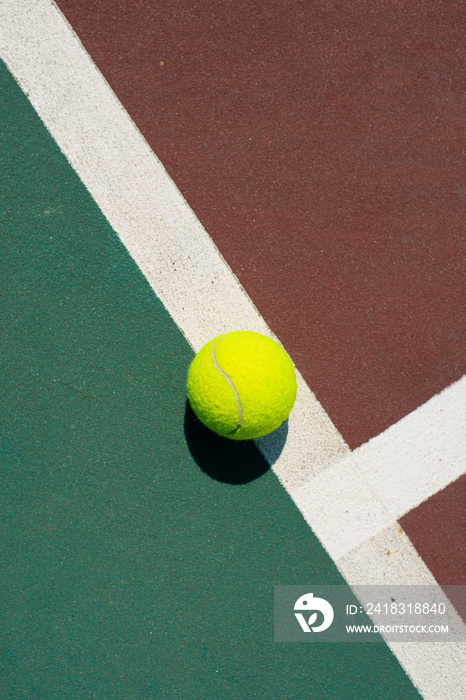 黄色网球躺在红色和绿色球场的线上。平面视图。文本空间