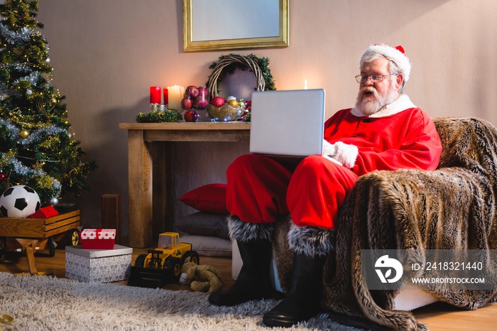 Santa Claus sitting and using laptop