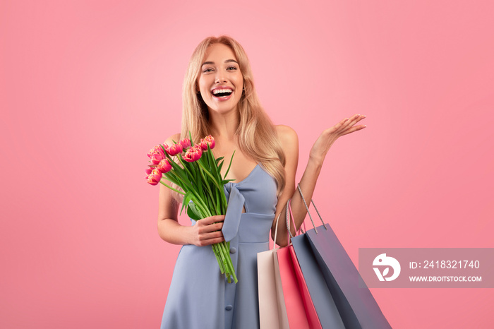 快乐的年轻女士，带着购物袋和一束郁金香，为春天的节日购买粉红色的礼物