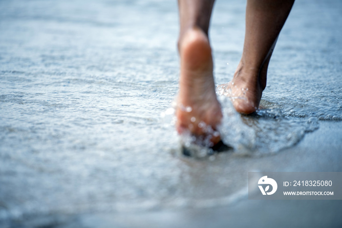 Woman barefoot walking on the beach