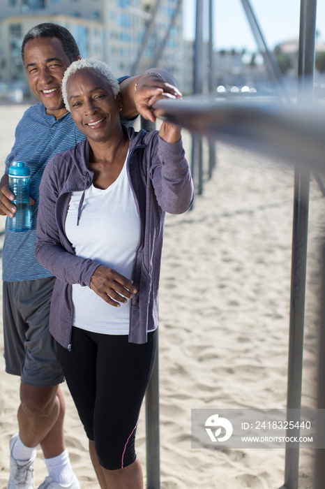 Portrait smiling senior couple exercising on beach