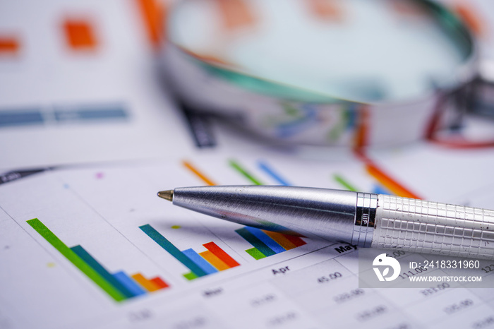 Pen and Magnifying glass on Graphs paper. Financial development, Banking Account, Statistics, Invest