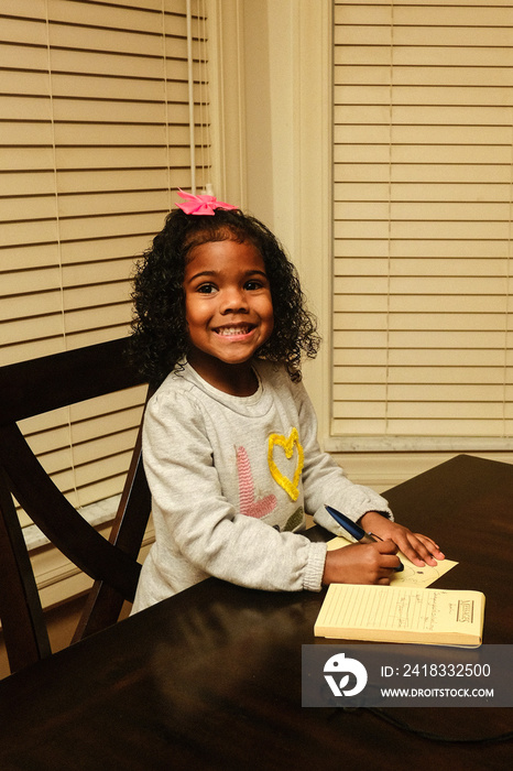 little girl  writing in notebook