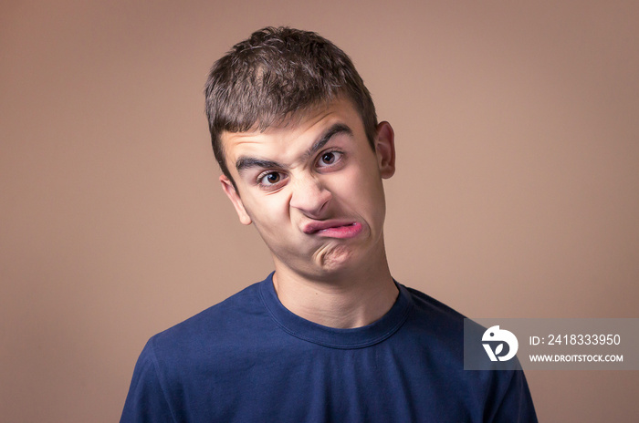 Young man with a goofy face. Human facial expression, body language funny