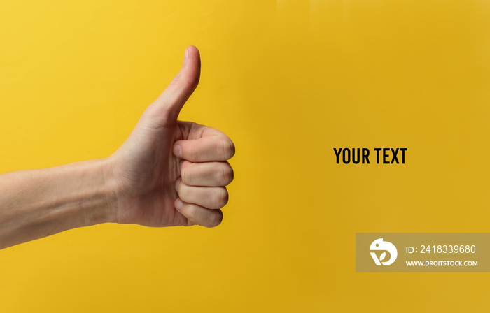 Female hand shows thumb up gesture on yellow background with space for your text