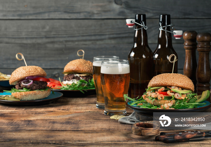 Variety of burgers with lager on the wooden table