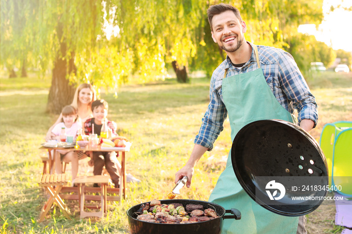 Man cooking tasty food on barbecue grill outdoors