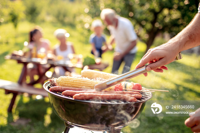 Man preparing food on garden barbecue