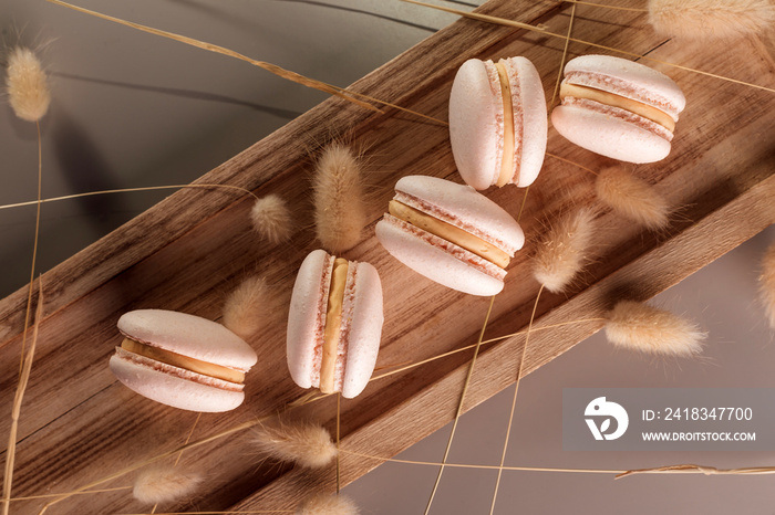 Desserts. Pastry, bakery and branding concept - French macaroons on cream beige background, parisian