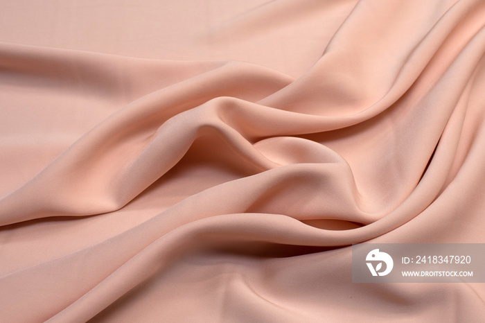 Fabric viscose (rayon). Color beige pink. Texture, background, pattern.