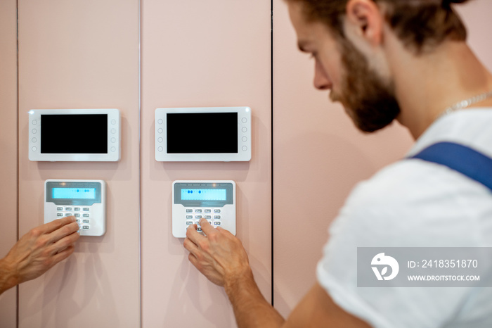 Workman setting up the alarm with keyboard near the entrance at home